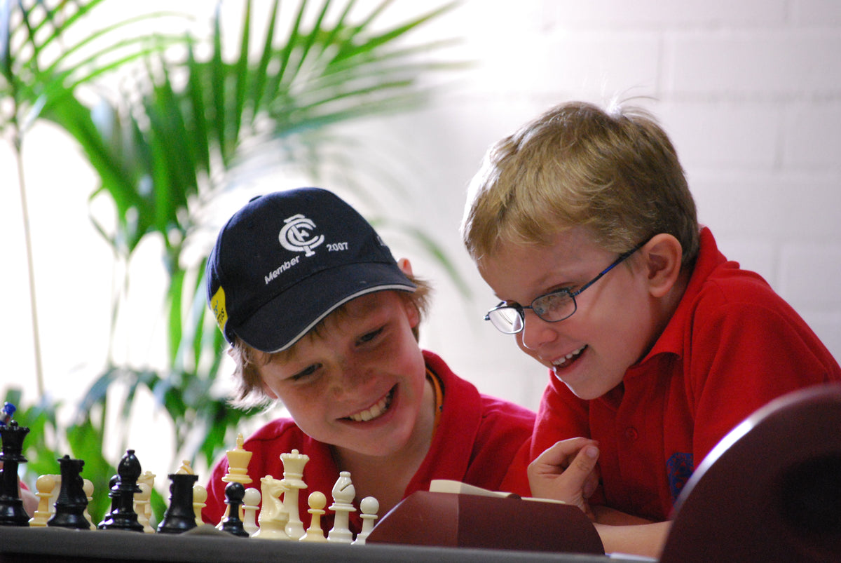 Chess coach analysing a position on a wooden board