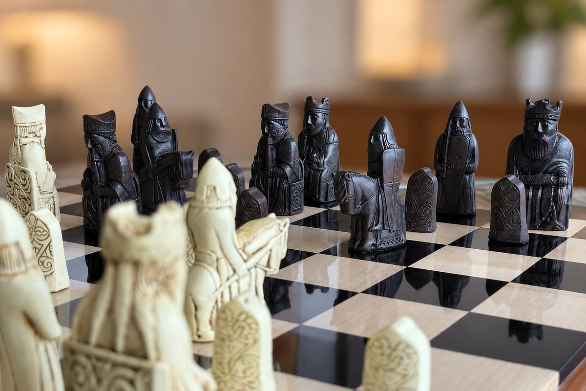 Isle of Lewis chess pieces facing off on a glossy black and maple chessboard