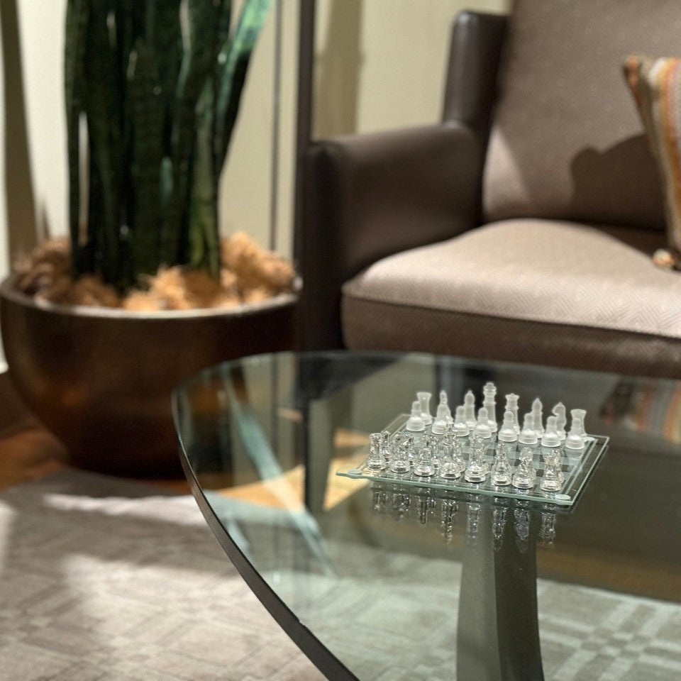 Mini glass chess set on a coffee table