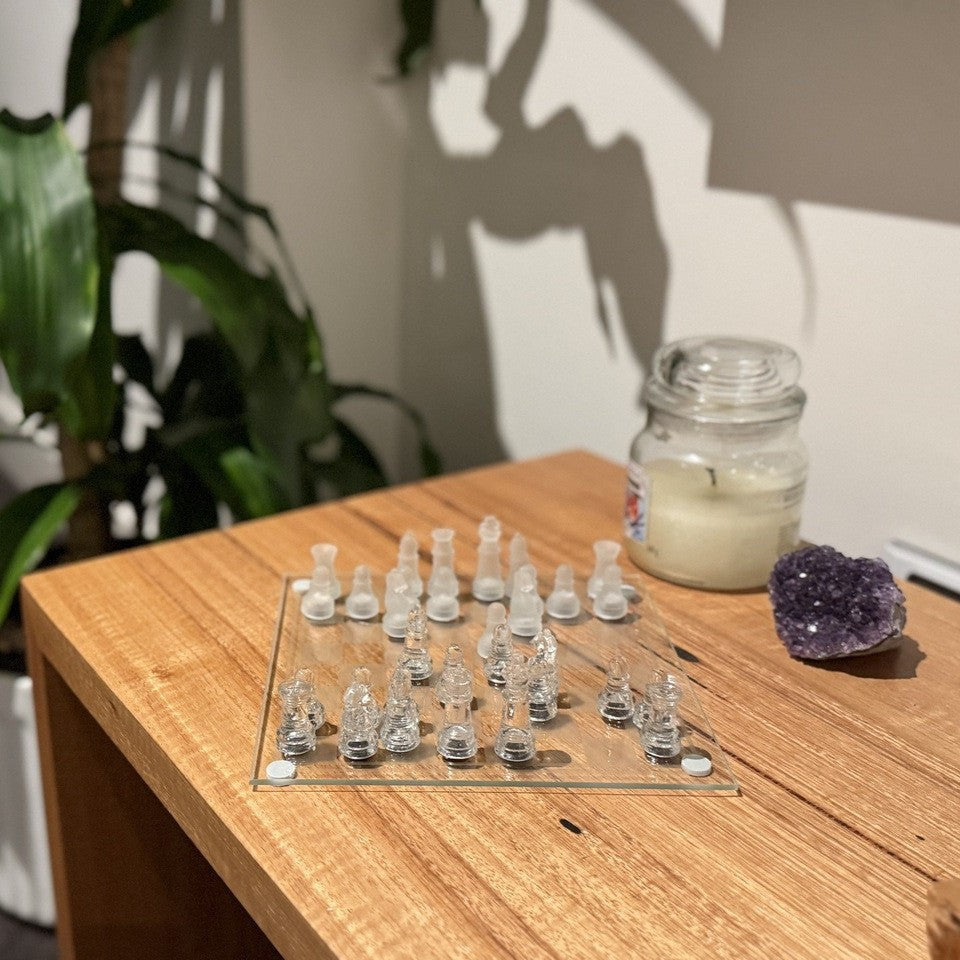 Mini glass chess set on a shelf